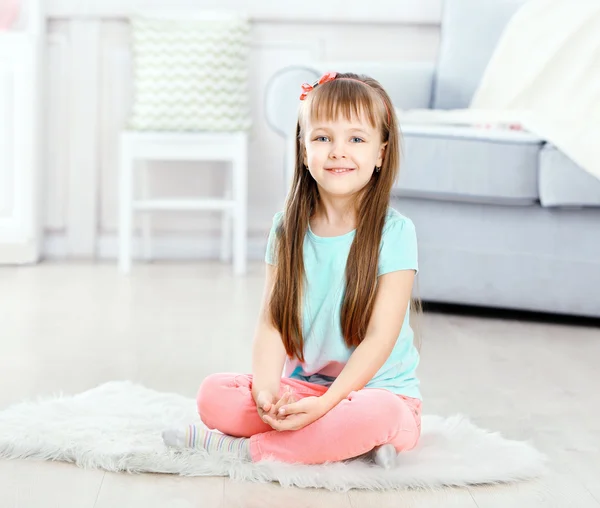 Flicka sitter på mattan — Stockfoto