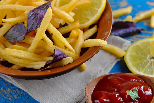 Patatas fritas en tazón con albahaca y salsa —  Fotos de Stock