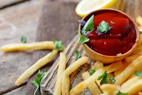 French fried potatoes in craft paper — Stock Photo, Image