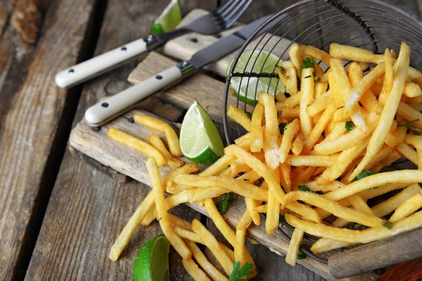 French fried potatoes in metal basket with sauce — Stock Photo, Image