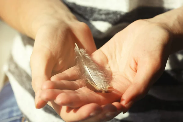 Manos sosteniendo una pluma —  Fotos de Stock