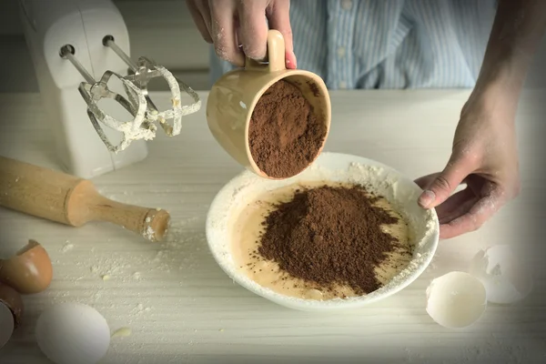 Woman is adding cocoa — Stock Photo, Image