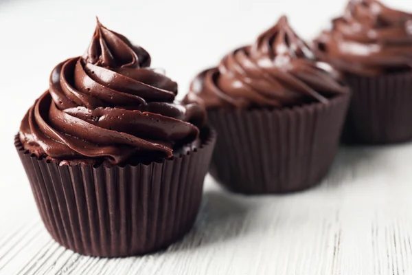 Chocolate cupcakes on wooden background — Stock Photo, Image