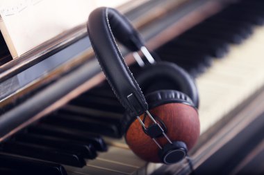 Piyano klavye üzerinde kahverengi kulaklık 