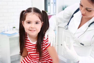 Bir çocuk enjeksiyon veren doktor