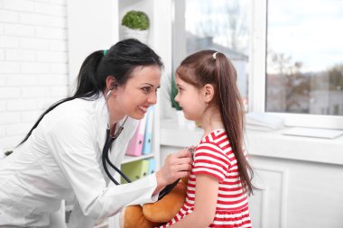 Doktor bir çocuğun ofiste incelenmesi
