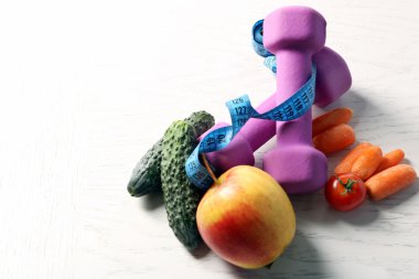 Dambıl ile sağlıklı meyve ve sebze ışık arka plan üzerinde