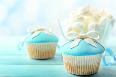 Parlak arka plan üzerinde renkli ahşap masa üzerinde yay ile lezzetli kek