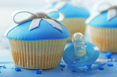 Renk ahşap arka plan üzerinde yay ve bebek emziği ile lezzetli kek