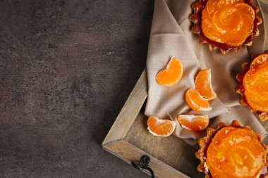 Tatlı kek üzerinde karanlık metal masa, mandalina ile yakın çekim