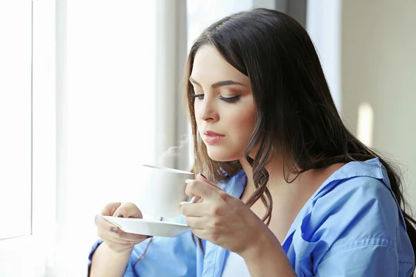 Junge Frau trinkt Kaffee — Stockfoto