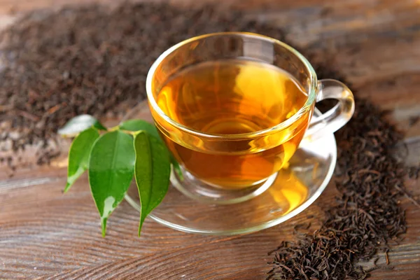 Tazza di tè di vetro con foglie verdi — Foto Stock