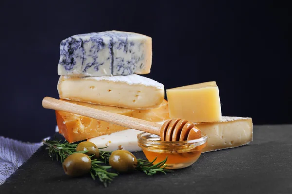 Diferentes tipos de queijo, mel e azeitonas na mesa, close-up — Fotografia de Stock