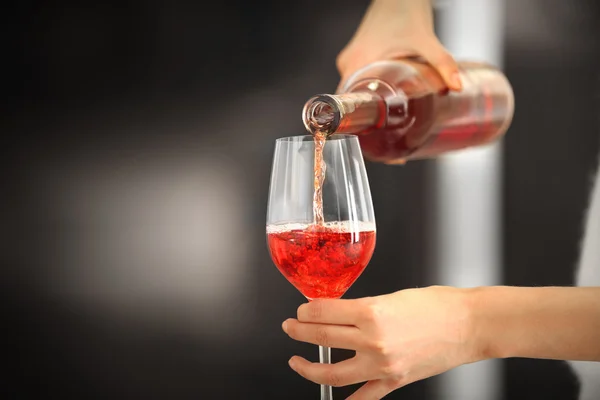 Frau schenkt rosa Wein ein — Stockfoto
