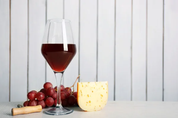 Vino tinto con queso y uva sobre fondo de pared de madera —  Fotos de Stock