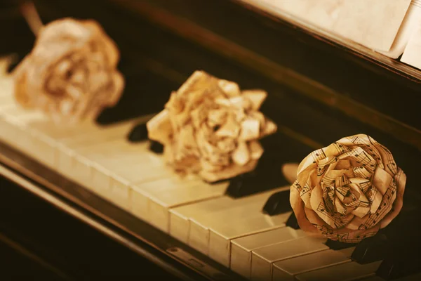 Rosas de papel decorativas en el teclado del piano — Foto de Stock