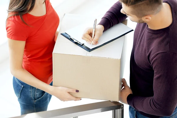 Man signing receipt of delivery package, close up