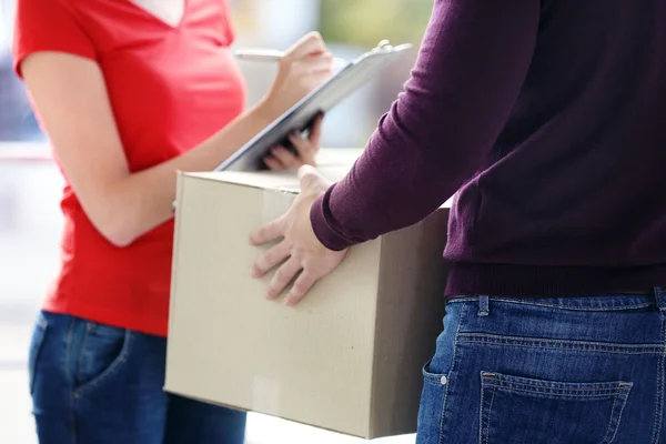 Woman signing delivery receipt — Stock Photo, Image