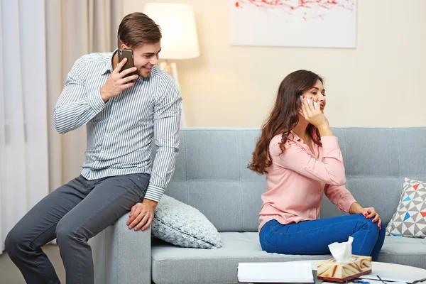 Met mobiele telefoons thuis (echt) paar — Stockfoto