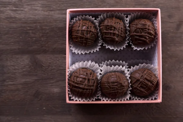 Doces de chocolate saborosos em caixa de presente rosa — Fotografia de Stock
