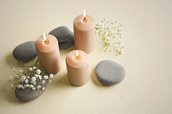 Beautiful composition of alight candles with pebbles — Stock Photo, Image