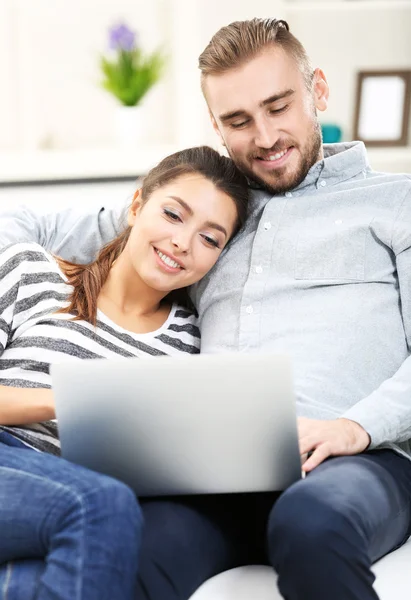 Casal feliz e trabalhando em um laptop — Fotografia de Stock