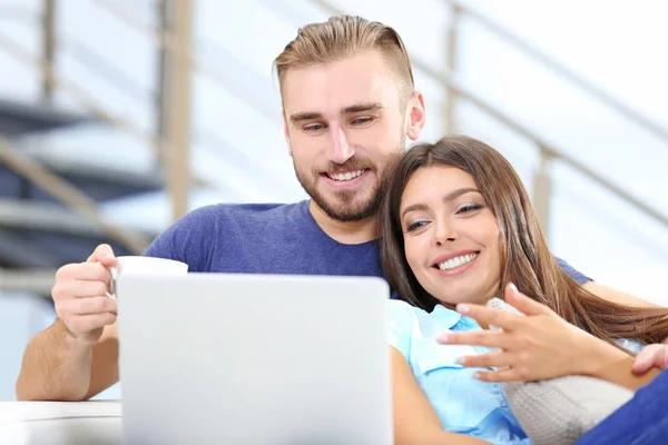 Pareja feliz sentada en sofá con café —  Fotos de Stock