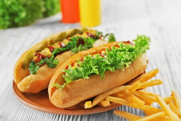 Delicious hot-dog with French fries and vegetables — Stock Photo, Image