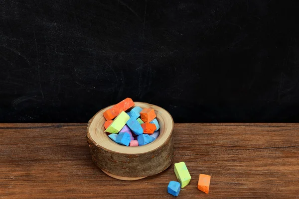 Wooden bowl of coloured chalk — Stock Photo, Image