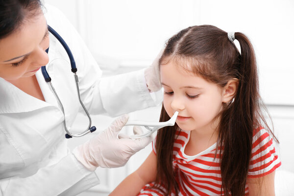 Врач осматривает нос ребенка
