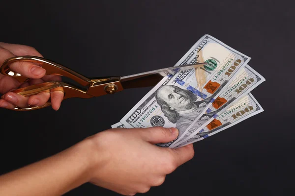 Handen met schaar snijden dollar — Stockfoto