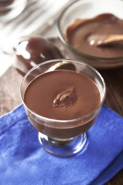 Melted chocolate in glass bowl, on wooden background — Stock Photo, Image