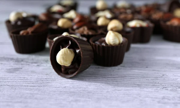 Deliciosos doces de chocolate na mesa de madeira, close-up — Fotografia de Stock