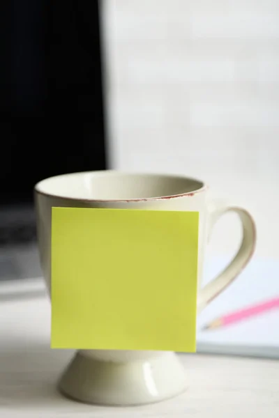 Yellow adhesive note on coffee cup, on laptop background — Stock Photo, Image