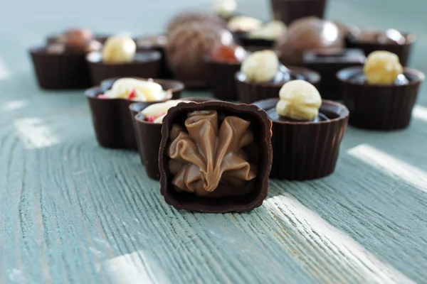 Doces de chocolate sortidas em fundo de madeira, close-up — Fotografia de Stock