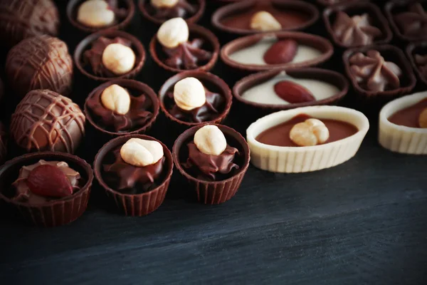 Köstliche Schokoladenbonbons auf blauem Holzhintergrund, Nahaufnahme — Stockfoto