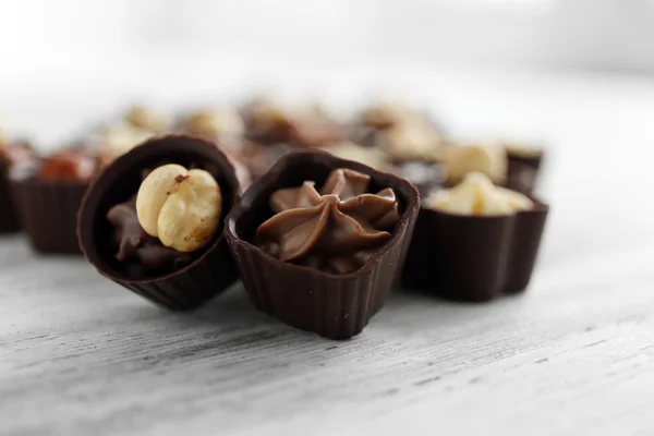 Pyszne czekoladowe cukierki na drewnianym stole, z bliska — Zdjęcie stockowe