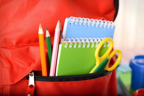 Red backpack with colourful stationary — Stock Photo, Image