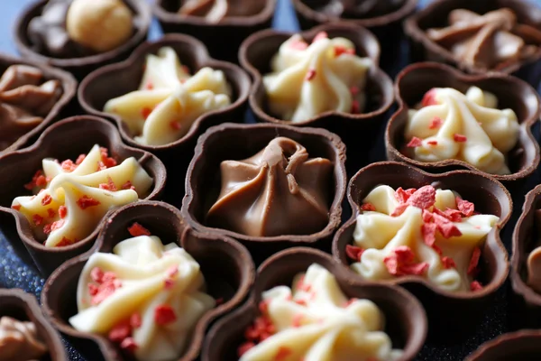 Sabrosos caramelos de chocolate de fondo, de cerca —  Fotos de Stock
