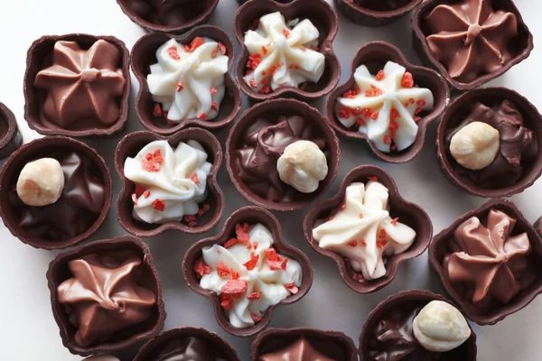 Composizione di caramelle al cioccolato su sfondo bianco, primo piano — Foto Stock