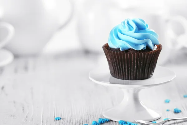 Delicious chocolate cupcake with blue cream on served table, close up — Stock Photo, Image