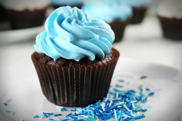 Delicioso cupcake de chocolate com creme azul na mesa de madeira decorada, close-up — Fotografia de Stock