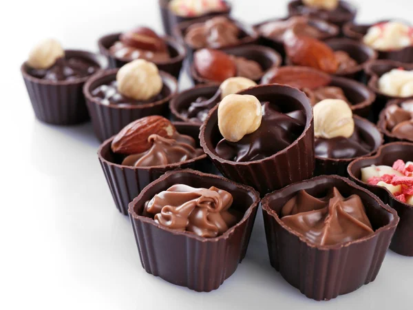 Pyszne czekoladowe cukierki na białym tle, z bliska — Zdjęcie stockowe