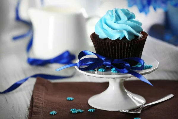 Delicioso cupcake de chocolate con crema azul en la mesa servida, de cerca —  Fotos de Stock