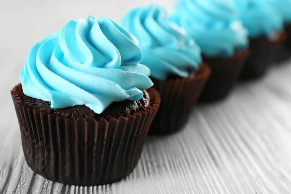 Deliciosos cupcakes sobre fondo de madera blanca, de cerca — Foto de Stock