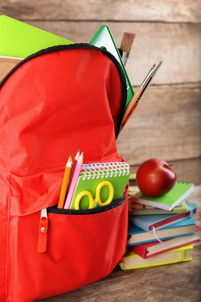 Red backpack with books and apple — Stock Photo, Image