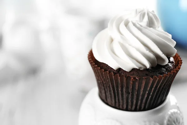 Delicious chocolate cupcake with cream on served table, close up — Stock Photo, Image