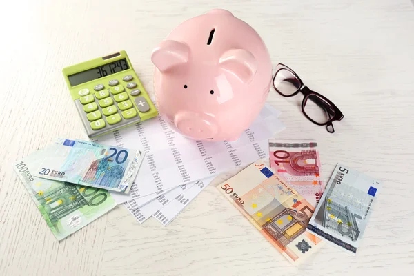 Piggy bank, calculator, euro and papers — Stock Photo, Image