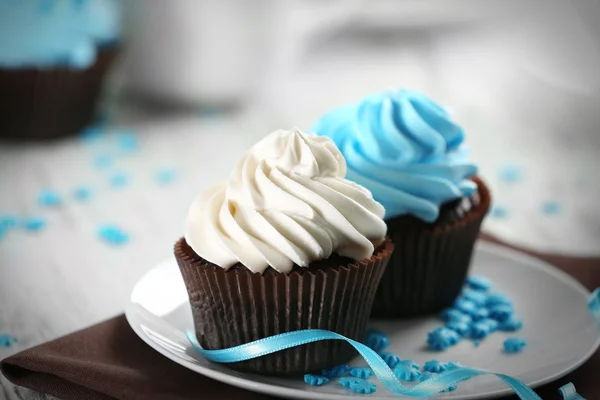 Chocolade cupcakes met kleurrijke crème op gedecoreerde tafel, close-up — Stockfoto