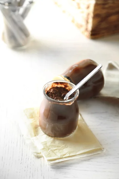 Postre de chocolate en pequeños frascos de vidrio sobre fondo de madera clara —  Fotos de Stock